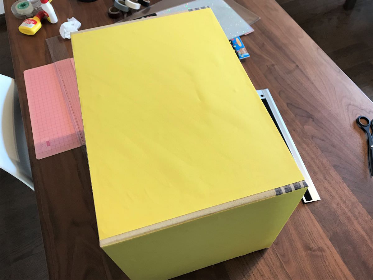 写真：箱に黄色い画用紙を貼りつける