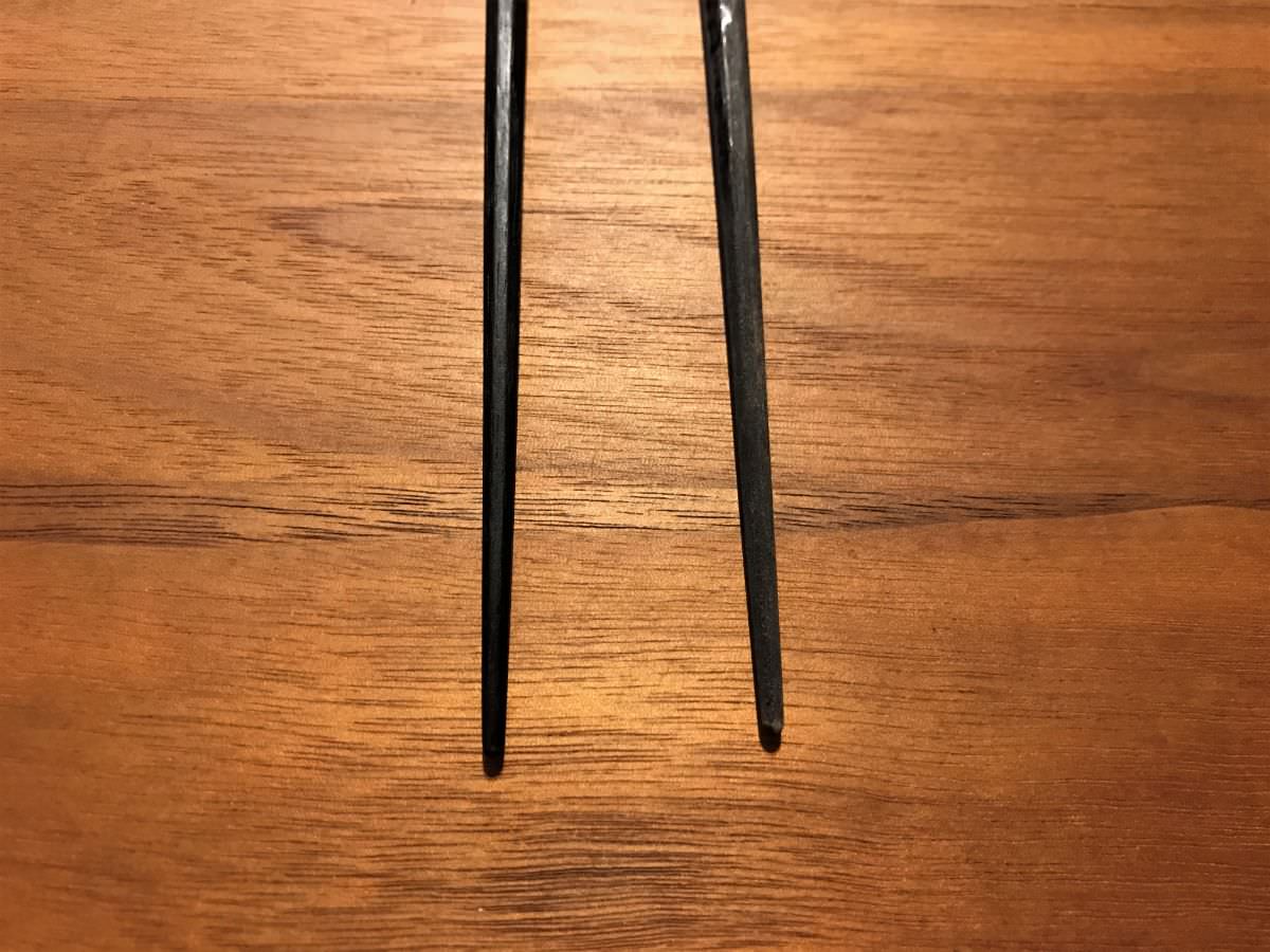 写真：黒い箸、左が蜜蝋ワックスを塗ったもの、右は塗る前。