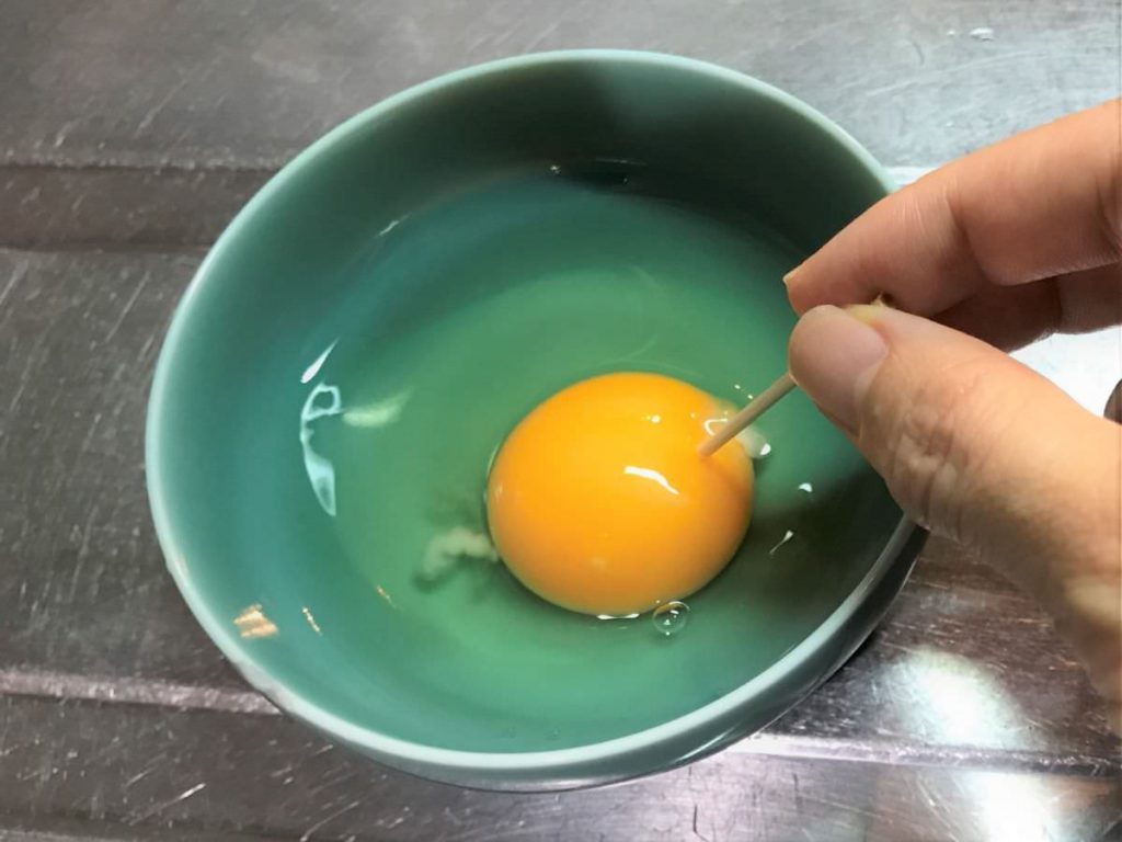 写真：チキン南蛮のタルタルソースを作る。卵を割る