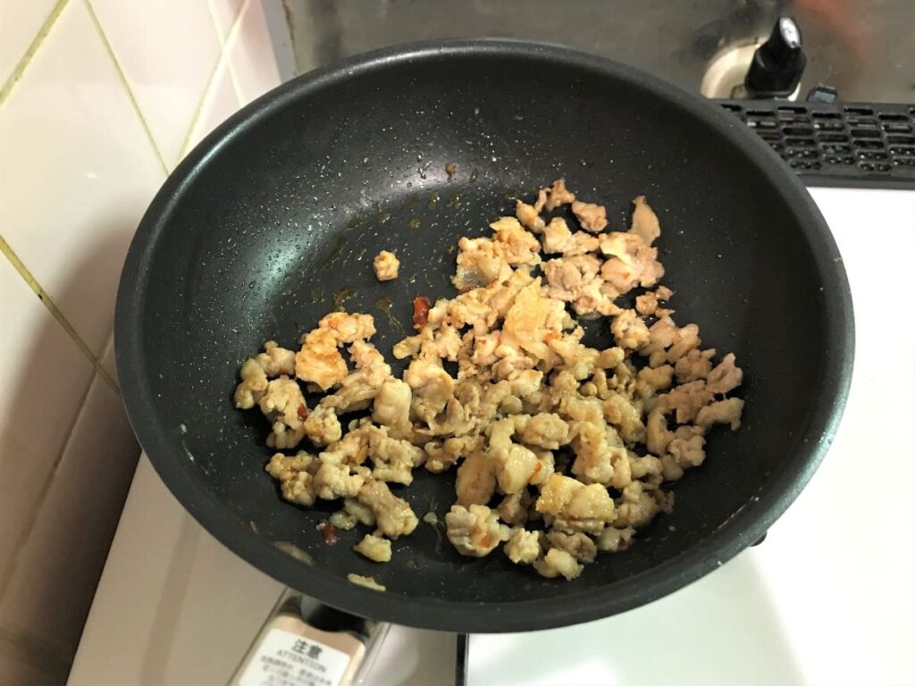 写真：細かめに切った豚肉を塩コショウ、豆板醤を入れて炒めます