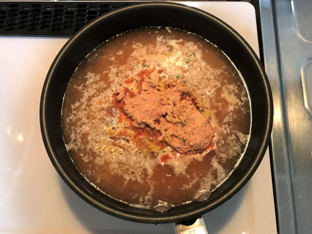 写真：業務スーパー フライパンひとつせかんたんパスタ トマト＆チーズパスタを煮ます