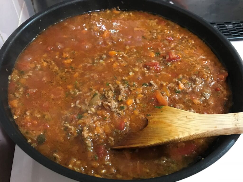 写真：野菜・ひき肉を炒めたら、トマト缶と水で煮込む