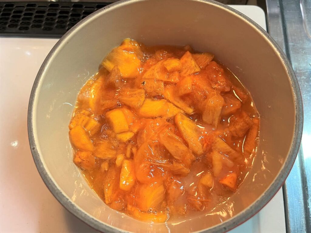 写真：柿を刻んで砂糖・レモン汁と一緒に鍋に入れます
