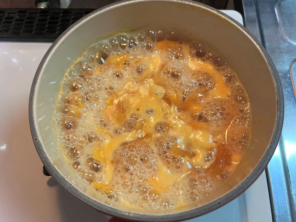 写真：柿ジャムを煮込む。灰汁が出てきました