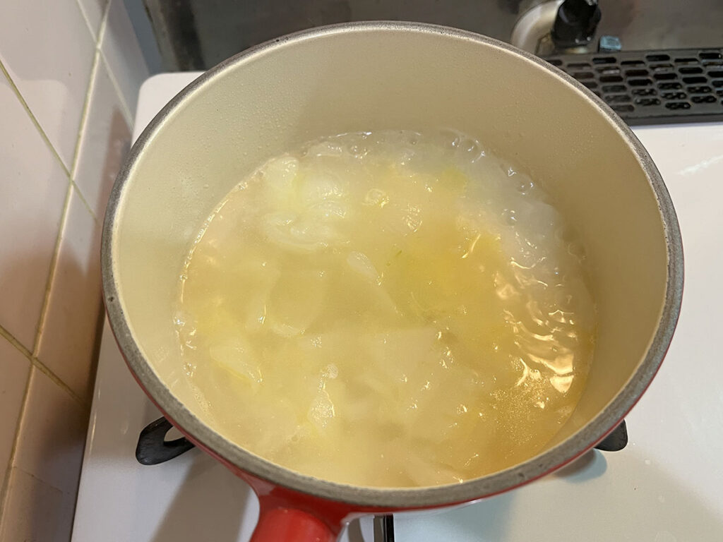 写真：調理中の水、バター、塩だけの新玉葱のスープ