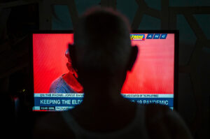 写真：ニュースをテレビで見る人