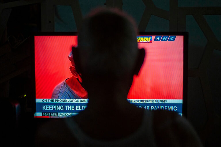 写真：ニュースをテレビで見る人